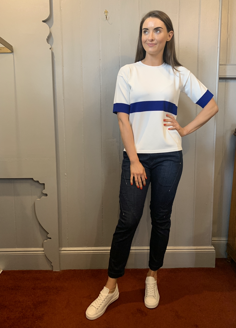 white short sleeve knit top with blue stripe across chest and sleeves